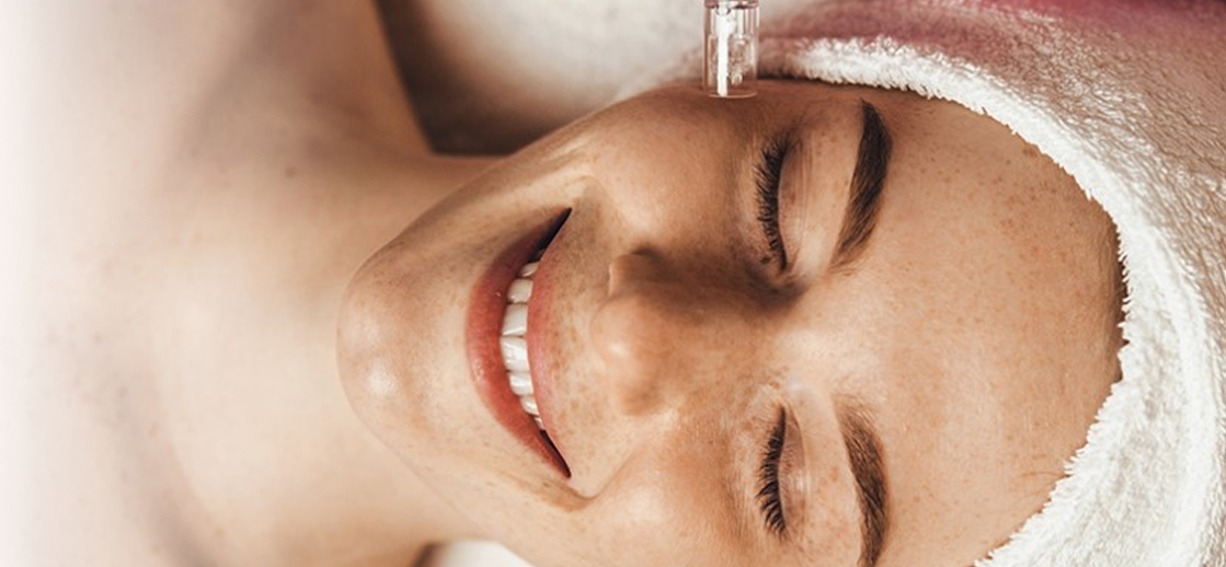 Smiling woman receiving advanced skin care treatment at Facials & Skincare by Debbie in Orange, CA.